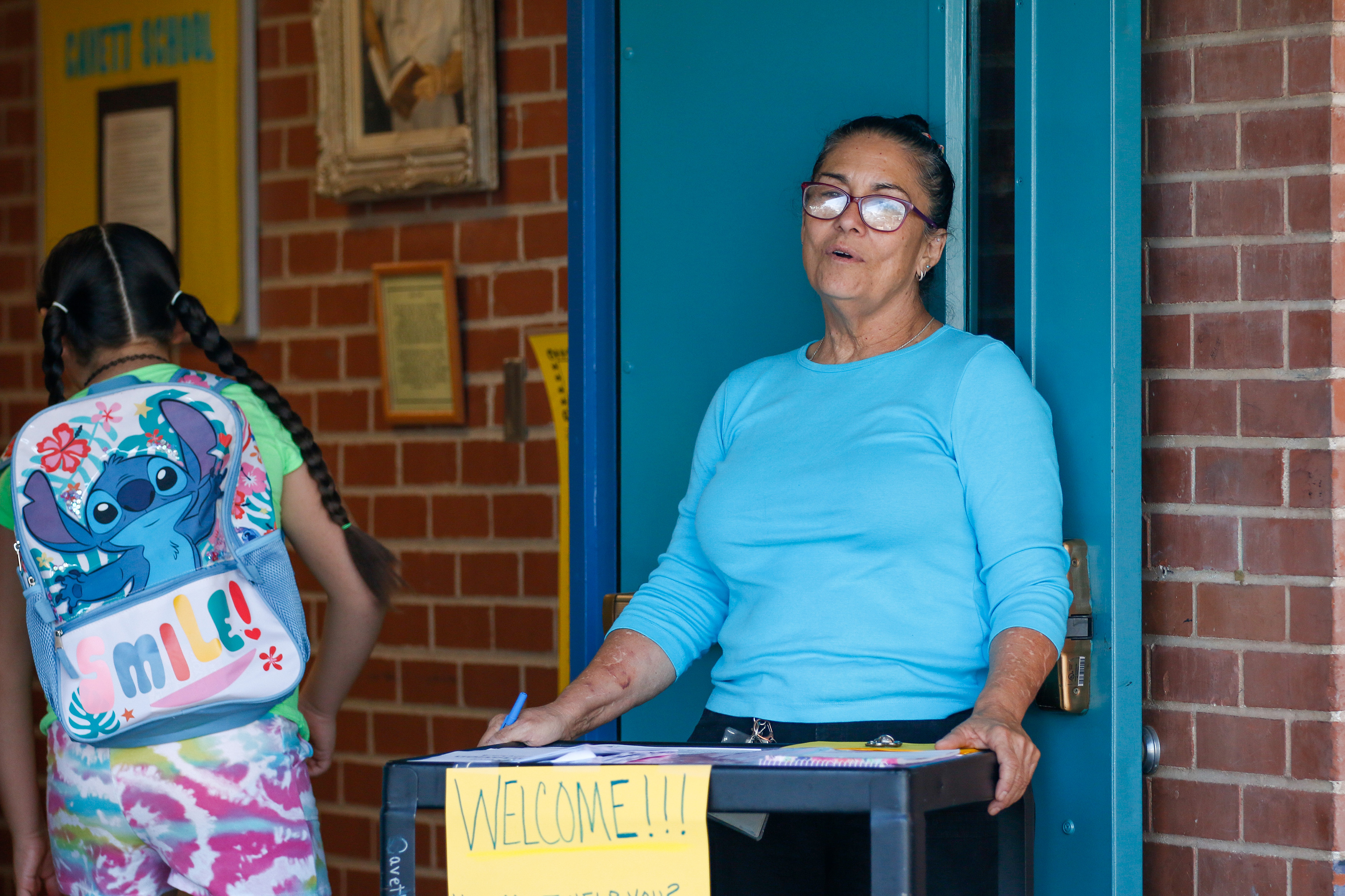 A Cavett staff member welcomes students outside