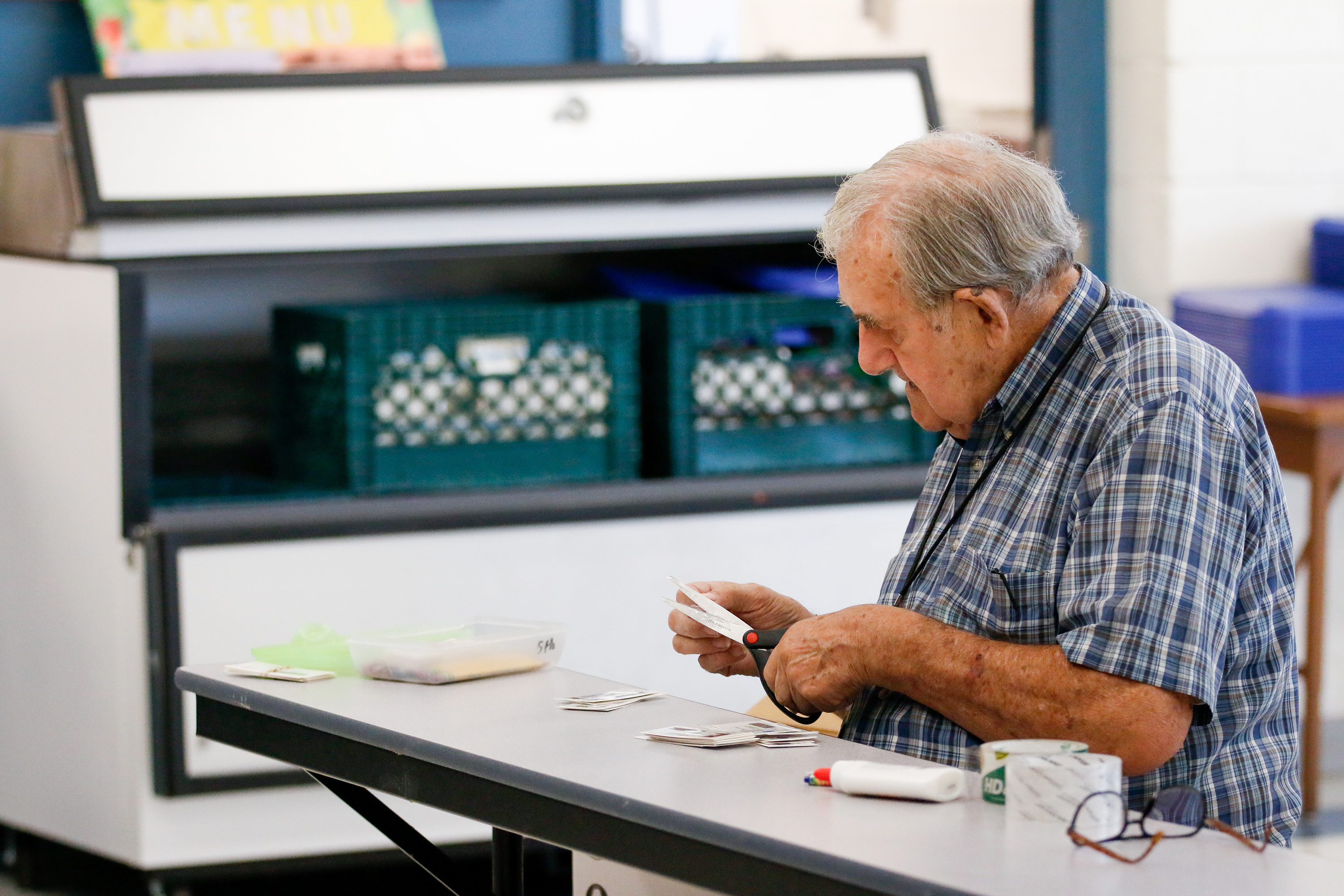 A teacher cuts out paper for his students